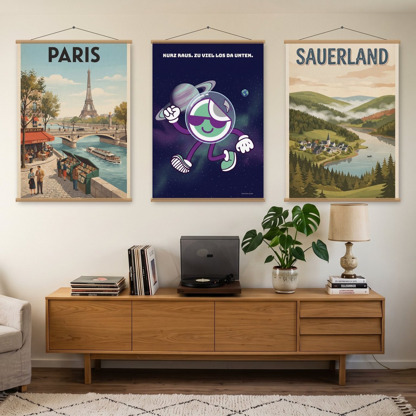 Drei große Poster – Paris, Dude im All und Sauerland – an Posterleisten über einem Sideboard