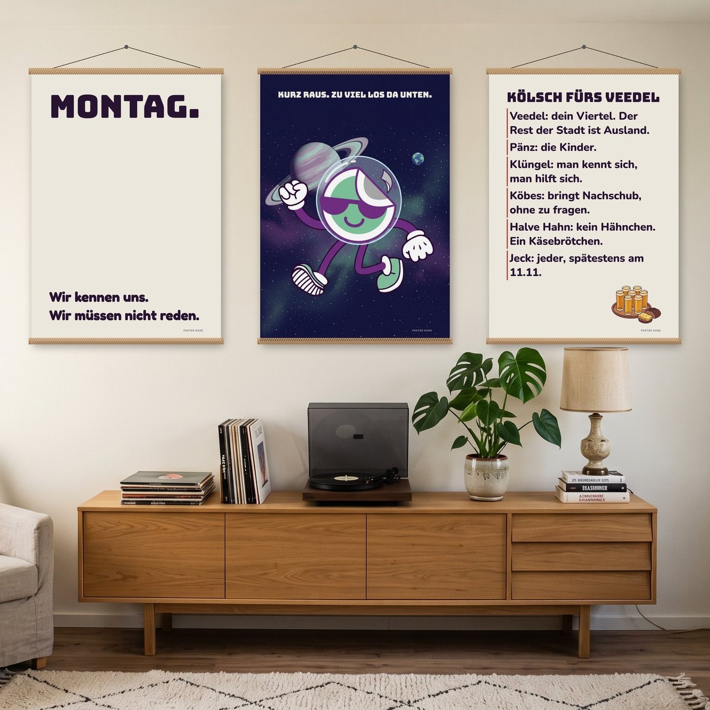 Drei große Poster mit Sprüchen und dem Dude an Posterleisten über einem Sideboard