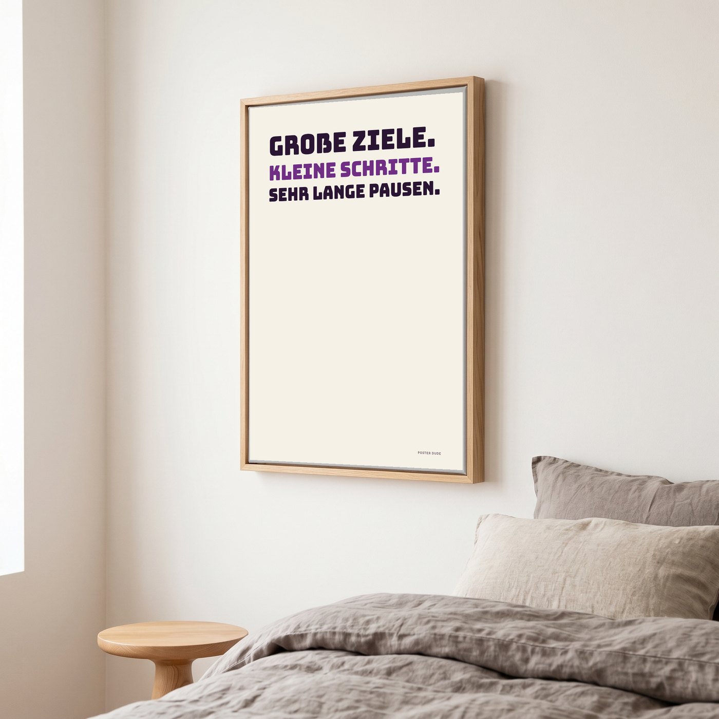 Stoffbild im Holzrahmen mit dem Motiv „Große Ziele“ über einem Bett